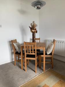 a dining room with a wooden table and chairs at Penthouse Seafront Largs in Largs