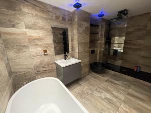 een badkamer met een wit bad en een wastafel bij Flat On The Shore in Edinburgh
