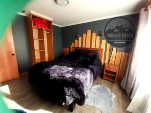1 dormitorio con 1 cama con edredón negro en Cabaña Posada El Refugio, en Malalcahuello