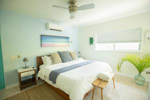 a white bedroom with a bed and a window at Casa Limonada Boutique Motel in Sarasota