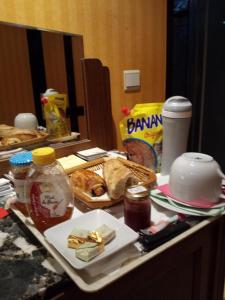 a cluttered counter top with bread and food on it at Chambres d'hôtes Olry in Nancy