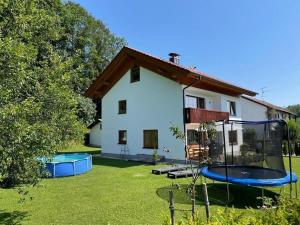 una casa con patio con cama elástica en Ferienhaus-Naehe-Kochel-am-See en Großweil