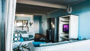 a blue living room with a couch and a tv at Campismo Ninho Villa 26 - Ponta Malongane in Ponta Malongane