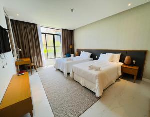 a hotel room with two beds and a large window at Sea view villa in Wyndham Garden Cam Ranh in Nha Trang +18 photos