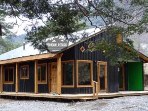 una casa con un exterior negro y verde en Cabaña Posada El Refugio, en Malalcahuello