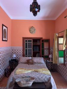 a bedroom with a bed and a chandelier at Riad Dar Pa Labzioui in Meknès