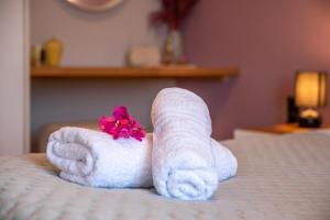 a pair of towels with a flower on a bed at Alexandros Luxury House in Falasarna