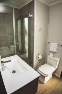 a bathroom with a white sink and a toilet at Quisquito Lodge & Spa - Punta de Lobos - Tina 24 Hrs in Pichilemu