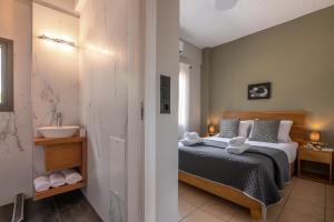 a bedroom with a bed and a bathroom with a sink at Alexandros Luxury House in Falasarna