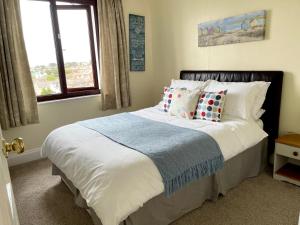 Un dormitorio con una cama con almohadas y una ventana. en ORCHARD HILL HOUSE Apartment, en Paignton