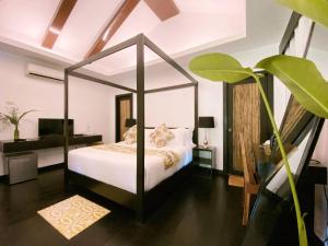 a bedroom with a canopy bed and a desk at Lio Villas Resort in El Nido
