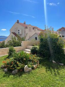 a house with a garden with a fountain at Apartments Mikulić in Bol