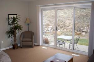 uma sala de estar com uma grande janela e uma mesa e cadeiras em Paradise Canyon Golf Resort - Luxury Condo M403 em Lethbridge