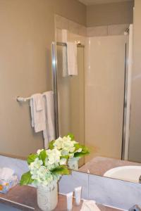 een badkamer met een vaas met bloemen op een toonbank bij Paradise Canyon Golf Resort - Luxury Condo M403 in Lethbridge