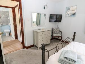 a bedroom with a bed and a dresser and a bathroom at Oakmead in Moreton in Marsh