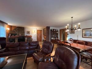 a living room with leather furniture and a table at Prades Cal Rueda in Prades