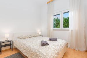 a bedroom with a bed with two slippers on it at Apartmani Vita, Ližnjan - apartman 1 in Ližnjan