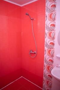 uma casa de banho vermelha com um chuveiro e uma parede vermelha em Lucky 2 em Pavel Banya