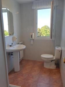 baño con lavabo y aseo y ventana en Casa rural Itxas Ertz, en Mendexa
