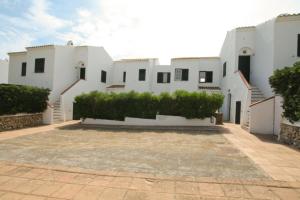 duży biały budynek z dziedzińcem przed nim w obiekcie Cove Noves - Relax en Menorca, Ideal para familias w mieście Punta Grossa