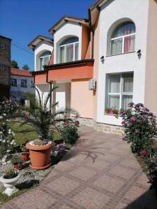 uma casa com plantas e flores à sua frente em Lucky 2 em Pavel Banya