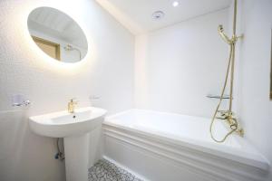 uma casa de banho branca com um lavatório e um espelho em Masan First Class Hotel em Changwon