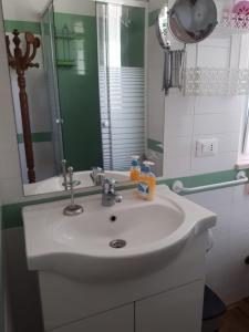 La salle de bains est pourvue d'un lavabo blanc et d'un miroir. dans l'établissement A Cento Metri dal Mare, à Senigallia