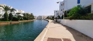 um canal de água com edifícios e palmeiras em Le Bleu Céleste em Hammamet