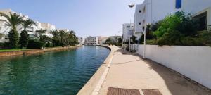 a canal of water with buildings and palm trees at Le Bleu Céleste in Hammamet