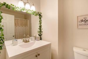 a bathroom with a sink and a mirror at Cozy Family Retreat with Arcade, Grill, Waffle Bar & Firepit in Norcross