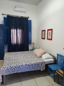 um quarto com uma cama e uma cortina azul em Casarão do Pontal em Coruripe