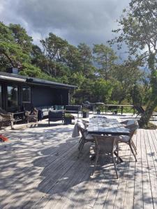 - une table de pique-nique et des chaises sur une terrasse en bois dans l'établissement Liten stuga med fantastiskt läge, à Tofta