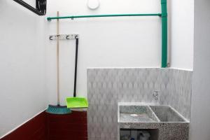 La salle de bains est pourvue d'un lavabo et d'une brosse verte. dans l'établissement CASA VERDE - APARAMENTOS BUCARAMANGa, à Bucaramanga