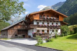 una casa en las montañas con flores en el balcón en Landhaus Grüner, en Sölden