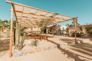 eine hölzerne Pergola mit einem Picknicktisch und einem Kaktus in der Unterkunft Cien Palmas- Authentic Mexican Casita 1 -Downtown in Todos Santos