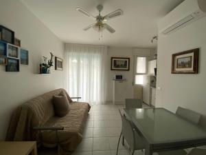 a living room with a couch and a ceiling fan at Villa Lidia 13 in Lido di Jesolo