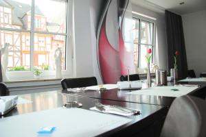 a dining room with a table and two windows at Hotel am Markt in Cochem
