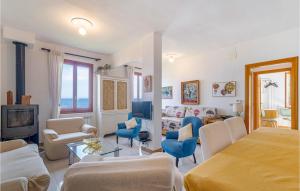 a living room with a couch and chairs and a tv at Casa Serena in Sori