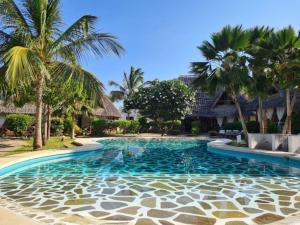 uma piscina num resort com palmeiras em Luxury boutique villa with gorgeous pool em Malindi