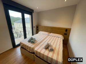 un dormitorio con una cama con dos animales de peluche en Apartaments Cal Bertran, en Bellver de Cerdanya 