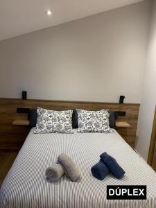 1 cama con 2 almohadas y 2 toallas. en Apartaments Cal Bertran, en Bellver de Cerdanya 