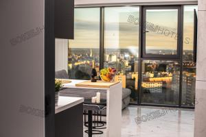 a living room with a view of a city at Hanza Tower - BokiejHotels, City View, 16th floor in Szczecin