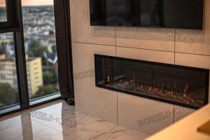 a fireplace in a living room with a view at Hanza Tower - BokiejHotels, City View, 16th floor in Szczecin