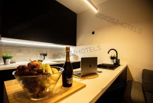 a bottle of wine and a bowl of fruit on a kitchen counter at Hanza Tower - BokiejHotels, City View, 16th floor in Szczecin