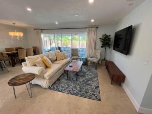 ein Wohnzimmer mit einem Sofa und einem Tisch in der Unterkunft Paradise 4 min to the Beach with Private Heated Pool in Deerfield Beach