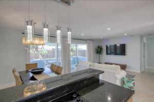 uma cozinha e sala de estar com uma mesa e um sofá em Paradise 4 min to the Beach with Private Heated Pool em Deerfield Beach