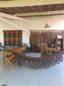 a hammock in a restaurant with a table and chairs at Casarão do Pontal in Coruripe