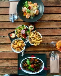 una mesa con tres platos de comida y papas fritas en Altes Pfarrhaus 