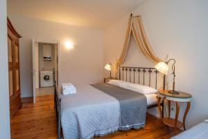 a bedroom with a bed with a blue blanket and a table at La casa di Terlago in Terlago