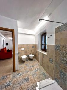 uma casa de banho com 2 WC e uma cabina de duche em vidro. em casa di natalie em Girasole